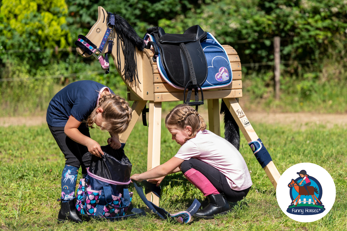 Photo: HKM Two girls rummage in a bag for accessories for their wooden horse.