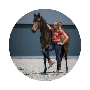 Yvet Blokesch has wrapped her right front leg around the left leg of her bay horse.
